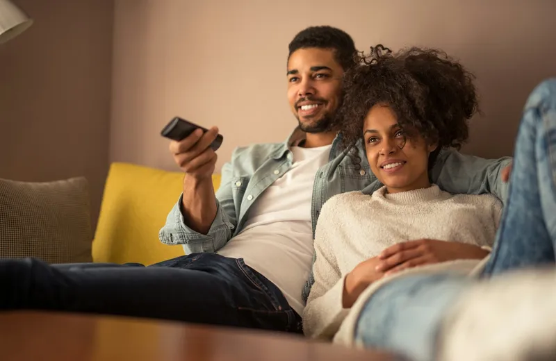 Couple relaxing on the sofa with a TV remote, watching a series — ViviMate series