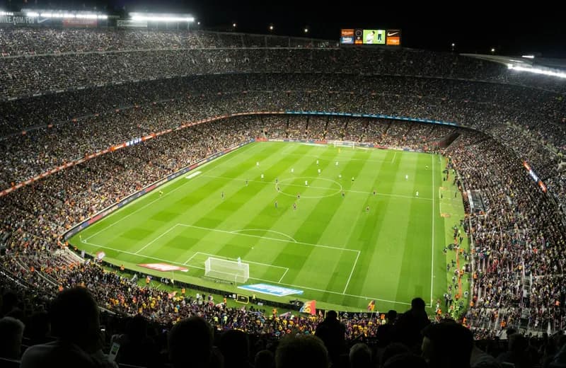 Packed football stadium under floodlights during a live match — ViviMate sports
