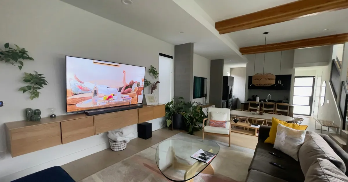 Large wall-mounted TV in a bright modern living room — ViviMate 4K and 8K