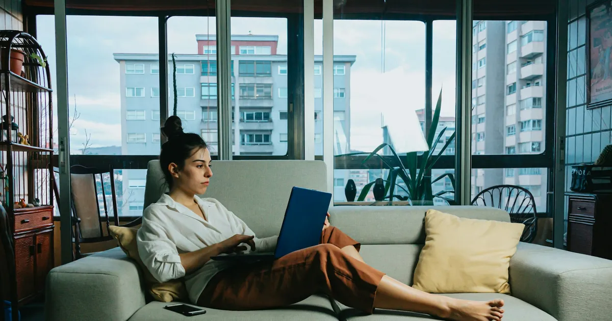 Woman on a sofa choosing a ViviMate subscription on her laptop