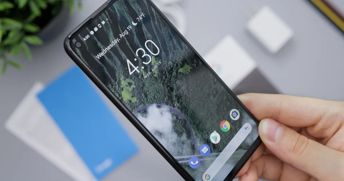Hand holding an Android smartphone showing the home screen — ViviMate on Android