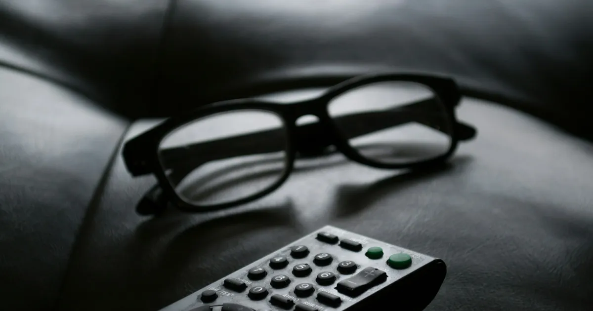 TV remote control resting on a sofa next to glasses — ViviMate catch-up