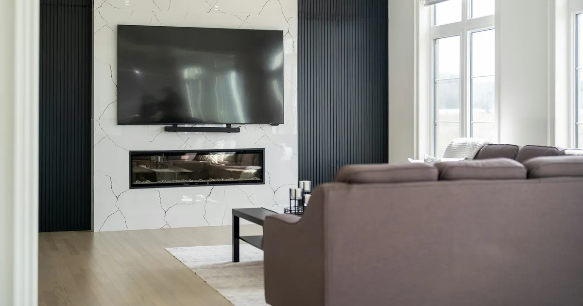 Modern living room with a large wall-mounted Smart TV above a fireplace — ViviMate on Smart TV